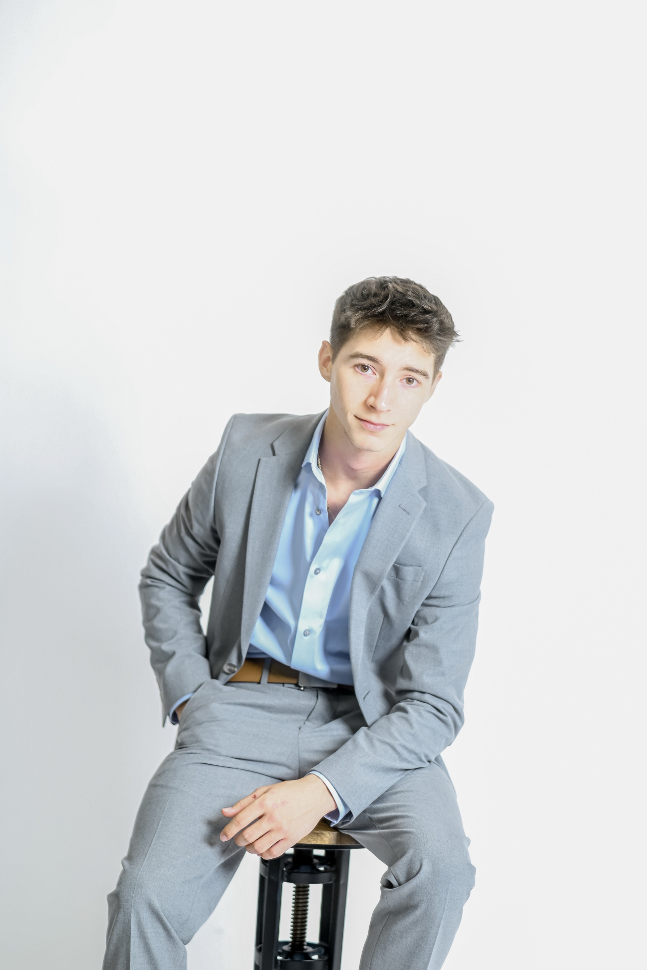 Founder of SMI Agency USA seated in a grey suit against a white studio backdrop